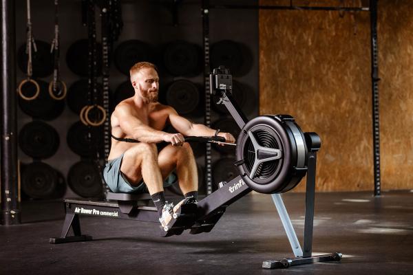 Veslovací trenažér TRINFIT Air Rower Pro model bez trička v úhlu